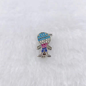 Macro shot of a polished silver boy charm with vibrant micro-set blue and pink zircons