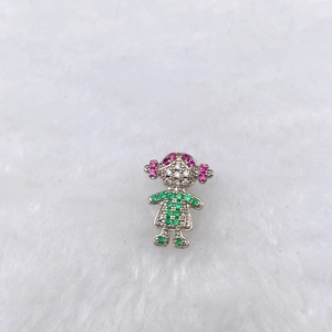 Macro shot of silver girl pendant with green pink and white zircon stones on white fur