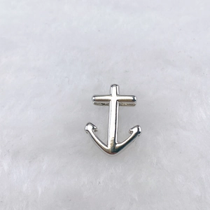 Gros plan d'un pendentif ancre en argent poli avec une finition métallique lisse pour bijoux