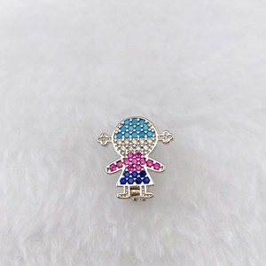 Detail of silver girl pendant with colorful zircon micro-paving on white fur background