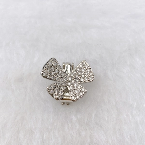 Close-up of a silver bow charm with sparkling zircons and a secure metal hinge clasp
