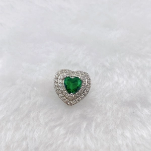 Close-up of heart-shaped charm with green gemstone and pavé white diamonds detail