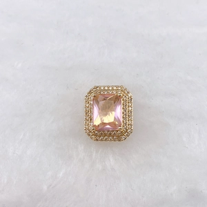 Detail of emerald-cut pink zircon charm with double layer pave on gold base
