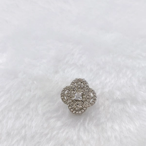 Detailed close-up of a silver clover pendant with white zircon micro-pave setting