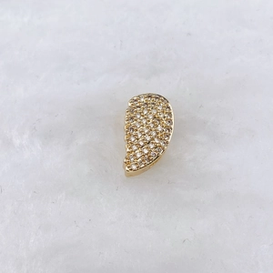 Vue macro d'un pendentif demi-cœur doré avec pavage de pierres en zircone cubique
