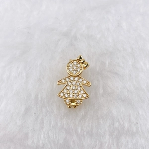 Detailed macro view of a gold girl pendant with sparkling cubic zirconia on plush background