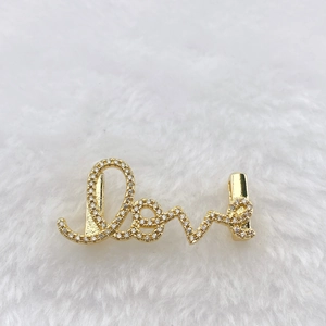 Macro shot of gold-plated Love letter pendant with pavé setting cubic zirconia