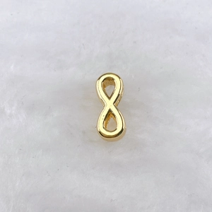 Détail macro d'un pendentif symbole infini doré poli pour bracelets bijoux DIY