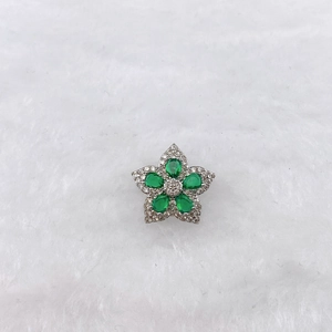 Macro shot of a five-petal flower pendant with green gemstones and white zircons