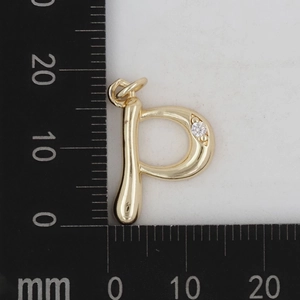 Makroaufnahme vom polierten Gold-Messing Buchstaben P Anhänger mit Zirkon und Maßstab