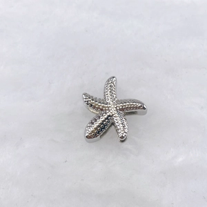 Détail d'une breloque étoile de mer à texture granulée pour bracelet DIY en métal argenté