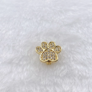 Macro shot of gold-plated paw charm with cubic zirconia for DIY bracelets