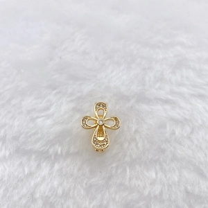 Close-up of golden clover pendant with micro-set zircons on white fur background