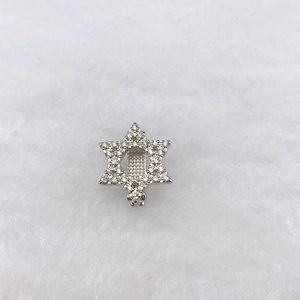 Macro shot of silver hexagram charm with sparkling pavé zircons and a secure metal loop