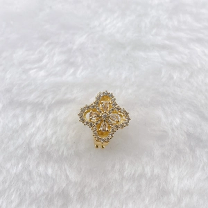 Macro shot of gold-plated flower clip earrings with clear crystals and pavé diamonds