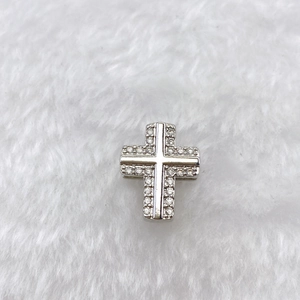 Detailed view of silver cross pendant charm featuring clear cubic zirconia insets