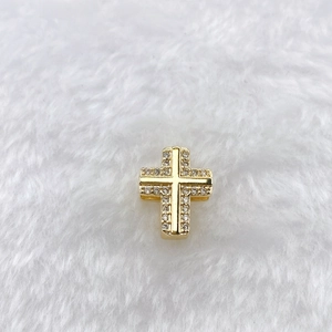 Detail view of a 10mm golden stainless steel cross charm with sparkling micro zircons