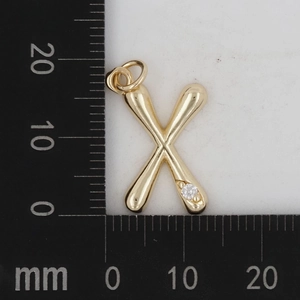 Makroaufnahme von Gold Messing Buchstabe X Anhänger mit Diamant und Maßen am Lineal