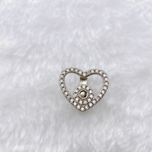 Detailed view of hollow heart charm with pave cubic zirconia on plush background