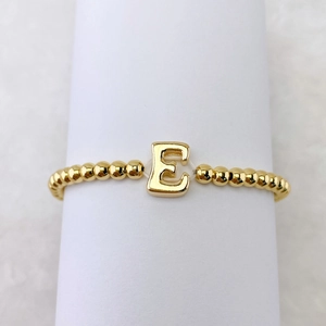 Detaillierte Nahaufnahme des 18k vergoldeten Perlenarmbands mit einem 3D Buchstaben-E