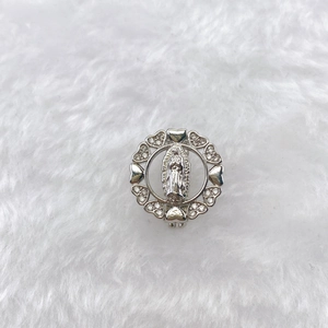 Macro shot of Virgin Mary pendant with heart borders and crystals on white fur