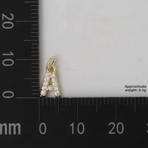 Vista macro del piccolo ciondolo lettera A dorata con zirconi e scala graduata