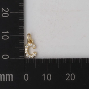 Misura dettagliata di un ciondolo a lettera C dorata con zirconi di 9mm di altezza su scala