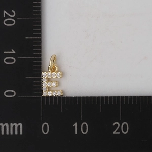 Dettaglio del ciondolo lettera E in oro con zirconi che mostra la misura di 10mm