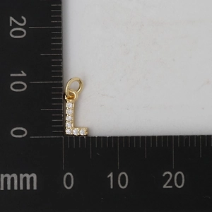 Vista macro che mostra l'altezza di 10mm del ciondolo a lettera L in oro e zirconi