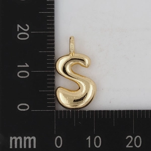 Goldener S-förmiger Buchstabenanhänger auf einem Lineal zur Darstellung der Größe