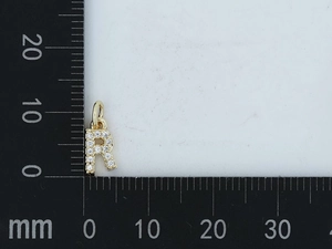 Dettaglio mini ciondolo lettera R dorata con zirconi, altezza circa 10 mm
