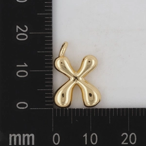 Makroaufnahme des goldenen X-Buchstabenanhängers, 13mm groß, mit Präzisionslineal