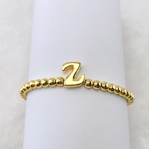 Detailansicht eines elastischen Perlenarmbands in 18 Karat Gold mit dem Buchstaben Z