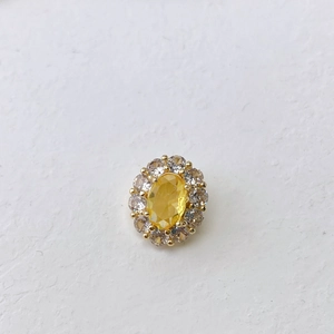 Detailed macro view of an oval yellow gemstone pendant with sparkling white diamond halo