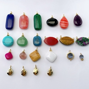 Macro shot of assorted colorful gemstone pendants in geometric shapes with gold bails