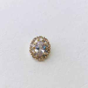 Macro detail of oval crystal necklace pendant with champagne zircon border in gold finish