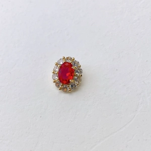 Detailed macro view of the oval red birthstone pendant surrounded by clear cubic zirconia