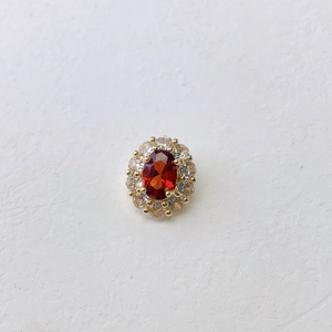 Macro detail of oval orange gemstone necklace with halo cubic zirconia setting
