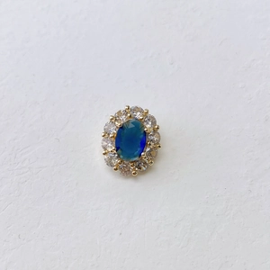 Close-up of vintage oval blue gemstone pendant with gold base and zircon stones