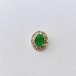 Close-up of oval green gemstone pendant with zircon halo and gold plating finish