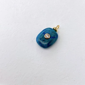 Macro shot of blue lapis lazuli pendant with gold trim and center zircon stone