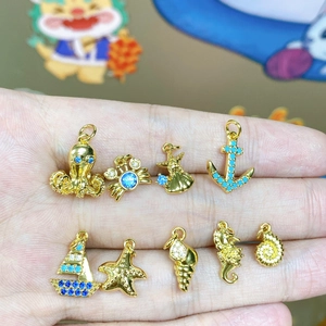 Set di ciondoli dorati a tema marino con stelle marine, cavallucci marini e conchiglie