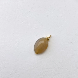 Macro-detail van ovale bruine edelsteen hanger met gouden metalen sluiting