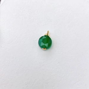 Detail van ronde groene kristallen hanger met ruitvormige facetten en gouden metalen lus