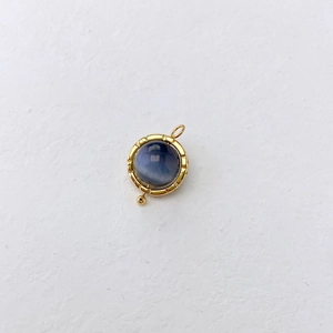 Close-up of a vintage round blue lapis lazuli pendant with a gold metal frame and decorative bead