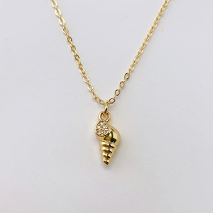 Dettaglio della collana con ciondolo a conchiglia dorata e pietre in zircone bianco