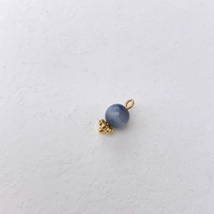 Macro detail of blue kyanite stone bead with gold metal cap and hook jewelry finding