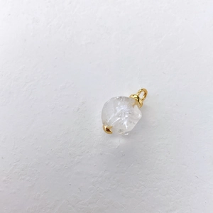Detailweergave van een natuurlijke witte kristallen hanger met gouden metalen sluiting