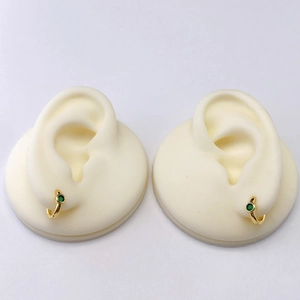 Orecchini a cerchio geometrici dorati con zircone verde intarsiato su modello bianco
