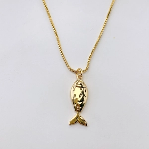 Dettaglio di una collana con ciondolo a forma di pesce dorato con finitura metallica ruvida